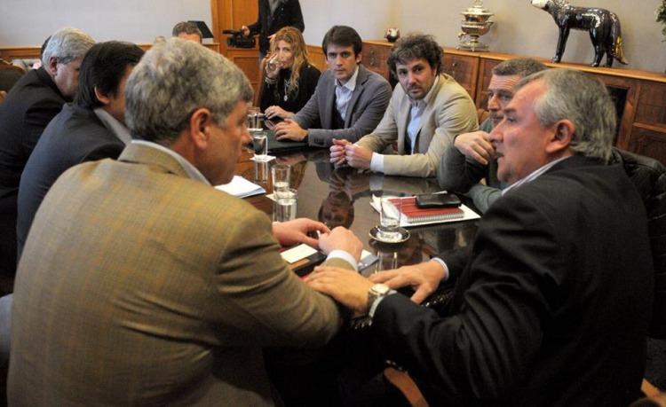 De traje gris oscuro, Rossi observa a Buryaile, su jefe, en una reuni&oacute;n con el gobernador juje&ntilde;o, Gerardo Morales