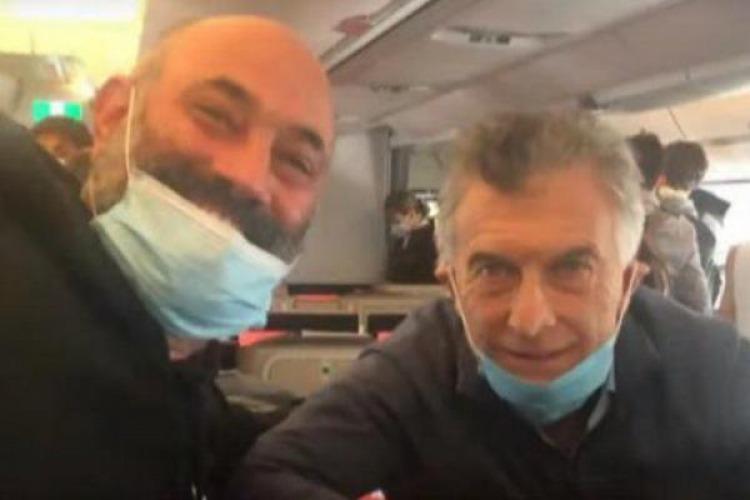 Mauricio Macri en el avi&oacute;n de regreso con el barbijo mal puesto